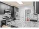 Modern kitchen with stainless steel appliances, granite countertops, tile backsplash, and dark cabinetry at 2865 Winter Rose Ct, Dunwoody, GA 30360
