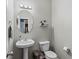 Small bathroom with a pedestal sink, oval mirror, and modern lighting at 4015 Arch Pass, Cumming, GA 30040