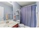 Bathroom with blue walls, shower with purple curtain, and floating shelves at 4015 Arch Pass, Cumming, GA 30040