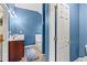 Bathroom with blue walls, single vanity, and tub with seat at 4015 Arch Pass, Cumming, GA 30040