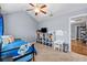 Well-lit bedroom with beige carpet, a ceiling fan, a blue bed, and adjacent storage space at 4015 Arch Pass, Cumming, GA 30040