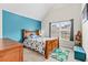 Bedroom with a teal accent wall, carpet, a wood bedframe, and a brightly-lit window at 4015 Arch Pass, Cumming, GA 30040