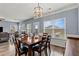 Bright dining area with a large window, stylish light fixture, and seamless flow to the living room and outdoor patio at 4015 Arch Pass, Cumming, GA 30040