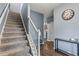 Inviting entryway features a carpeted staircase, wood floors, and stylish decor including a clock and console table at 4015 Arch Pass, Cumming, GA 30040