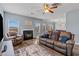 Cozy living room with a fireplace, leather seating, and a ceiling fan at 4015 Arch Pass, Cumming, GA 30040