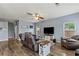 Spacious living room featuring hardwood floors, recliners, a ceiling fan, and a mounted television at 4015 Arch Pass, Cumming, GA 30040