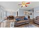 Open-concept living room featuring a comfortable leather sofa, hardwood floors, and seamless access to the dining area at 4015 Arch Pass, Cumming, GA 30040