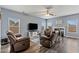 Bright living room featuring hardwood floors, recliners, a ceiling fan, a fireplace and natural lighting at 4015 Arch Pass, Cumming, GA 30040