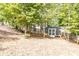 View of the backyard shed in a wooded area with a sloped lawn and a wooden fence at 4090 Cooks Farm Nw Dr, Kennesaw, GA 30152