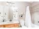 Bright bathroom with a bathtub and shower with a white shower curtain and neutral tile at 4090 Cooks Farm Nw Dr, Kennesaw, GA 30152