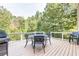 Backyard deck with an outdoor dining table, a grill, and wooded view at 4090 Cooks Farm Nw Dr, Kennesaw, GA 30152