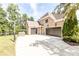 A brick house with a three-car garage, basketball hoop, and concrete driveway at 4090 Cooks Farm Nw Dr, Kennesaw, GA 30152