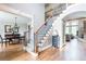 Open foyer with hardwood floors, staircase with wrought iron railings, and views into the dining and living areas at 4090 Cooks Farm Nw Dr, Kennesaw, GA 30152
