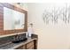 Stylish half bath featuring granite countertops, black sink, wood framed mirror, and decorative wall art at 4090 Cooks Farm Nw Dr, Kennesaw, GA 30152