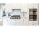 Stylish kitchen featuring stainless steel oven and microwave with granite countertops, and white cabinets at 4090 Cooks Farm Nw Dr, Kennesaw, GA 30152