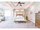 Elegant main bedroom featuring a canopy bed, sitting area, dresser, and neutral carpeting at 4090 Cooks Farm Nw Dr, Kennesaw, GA 30152