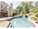 A luxurious backyard with a stunning pool, spa, rock waterfall feature, and lush greenery at 4090 Cooks Farm Nw Dr, Kennesaw, GA 30152