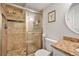 Tiled bathroom featuring a glass shower, granite countertop vanity, decorative mirror, and modern fixtures at 4125 Fallbrook Dr, Duluth, GA 30096