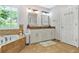 Elegant bathroom with a soaking tub, double vanity with granite countertops, and a window offering scenic views at 4125 Fallbrook Dr, Duluth, GA 30096