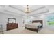 Spacious bedroom showcasing a large bed, dresser, and a stylish chandelier illuminating the room at 4125 Fallbrook Dr, Duluth, GA 30096