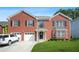 Charming red brick two-story home featuring an attached garage and a well-manicured front lawn at 4125 Fallbrook Dr, Duluth, GA 30096