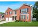 Beautiful brick home featuring a lush green lawn, mature landscaping, and a classic architectural design at 4125 Fallbrook Dr, Duluth, GA 30096