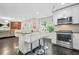 Open concept kitchen with stainless appliances, granite counters, island seating that leads to the living room at 4125 Fallbrook Dr, Duluth, GA 30096