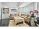 Bright living room featuring a comfortable sectional sofa, hardwood floors, and a large window at 4125 Fallbrook Dr, Duluth, GA 30096