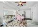 Bright loft area featuring dark wood floors, a ceiling fan, a pink desk and chair, and access to an outdoor balcony at 4125 Fallbrook Dr, Duluth, GA 30096