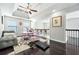 Bright loft area featuring dark wood floors, a ceiling fan, a pink desk and chair, and access to an outdoor balcony at 4125 Fallbrook Dr, Duluth, GA 30096