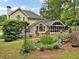 Back of home with light tan siding, gray roof, screened-in porch, deck, and beautiful landscaped yard at 5625 Brookstone Nw Dr, Acworth, GA 30101