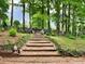 Tranquil backyard with a firepit and natural log steps amongst the trees at 5625 Brookstone Nw Dr, Acworth, GA 30101
