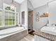 Bright bathroom featuring a soaking tub beneath a window and granite countertops at 5625 Brookstone Nw Dr, Acworth, GA 30101
