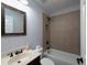 A cozy bathroom featuring a modern vanity, tiled shower, and framed mirror at 1205 Renaissance Se Ct, Mableton, GA 30126