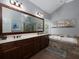 Large bathroom featuring a double vanity, soaking tub, and expansive mirror with modern lighting at 1205 Renaissance Se Ct, Mableton, GA 30126