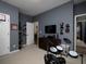 A well-lit bedroom features neutral carpets, gray-blue walls, and various decorative items at 1205 Renaissance Se Ct, Mableton, GA 30126