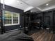 This home gym with black rubber and wood floors features workout equipment and natural light at 1205 Renaissance Se Ct, Mableton, GA 30126