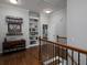 Upstairs hallway featuring hardwood floors, built in shelving, staircase with iron balusters, and transom windows at 1205 Renaissance Se Ct, Mableton, GA 30126