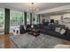 Spacious living room with a fireplace, large sectional sofa, and connection to the modern kitchen at 1205 Renaissance Se Ct, Mableton, GA 30126