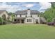 A beautiful home exterior with a large, well-maintained backyard and covered patio at 134 Johnston Farm Ln, Woodstock, GA 30188