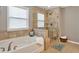 Bathroom featuring a tiled shower with glass door and a soaking tub by the window at 134 Johnston Farm Ln, Woodstock, GA 30188
