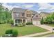 Charming two-story home with stone accents, a manicured lawn, and a two-car garage at 134 Johnston Farm Ln, Woodstock, GA 30188