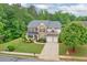 Beautiful two-story home with stone and brick exterior, manicured lawn, and a two-car garage at 134 Johnston Farm Ln, Woodstock, GA 30188
