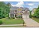 Beautiful two-story home featuring a stone facade, manicured lawn, and attached two car garage at 134 Johnston Farm Ln, Woodstock, GA 30188