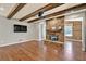 Inviting living room boasts a stone fireplace, wood beams, and rich hardwood flooring at 134 Johnston Farm Ln, Woodstock, GA 30188
