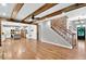 Open concept living room and kitchen featuring hardwood floors and a brick-accented staircase at 134 Johnston Farm Ln, Woodstock, GA 30188
