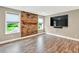 The living room features hardwood floors, a brick accent wall and natural light at 134 Johnston Farm Ln, Woodstock, GA 30188