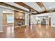Open-concept living space featuring stone fireplace, wood beams, and hardwood floors at 134 Johnston Farm Ln, Woodstock, GA 30188