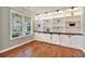 Home office with built-in bookshelves, storage cabinets, and hardwood flooring at 134 Johnston Farm Ln, Woodstock, GA 30188