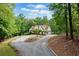 Exterior shot features winding driveway leading to the house surrounded by lush trees at 1825 Epperson Rd, Canton, GA 30115